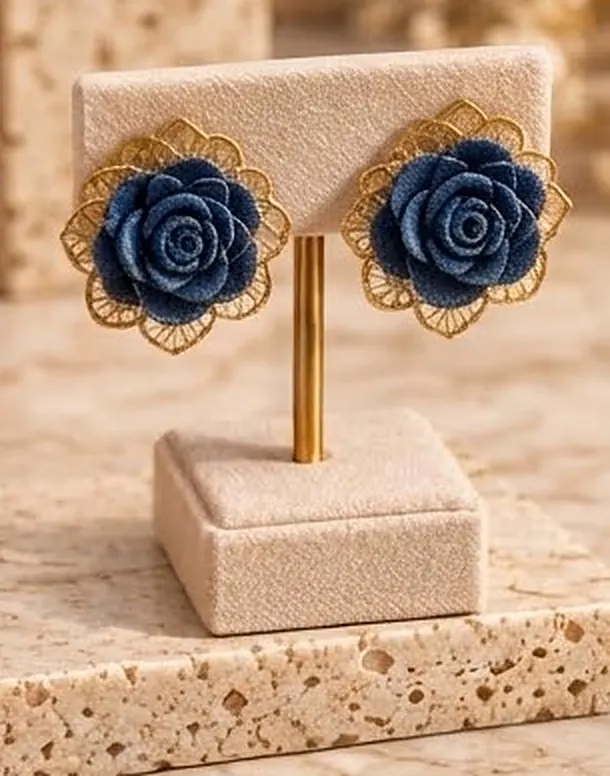 Denim rose earrings with gold filigree on a velvet stand