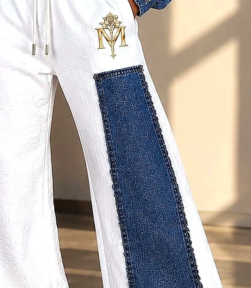Close-up of the Luxe sweatpant denim panel and gold monogram