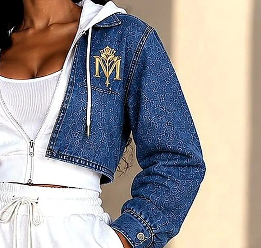 Close-up of the Denim Living in Luxe cropped denim jacket with gold rose monogram